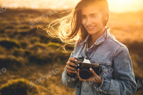 Preview: Smiling Woman Holding a Camera During Golden Hour