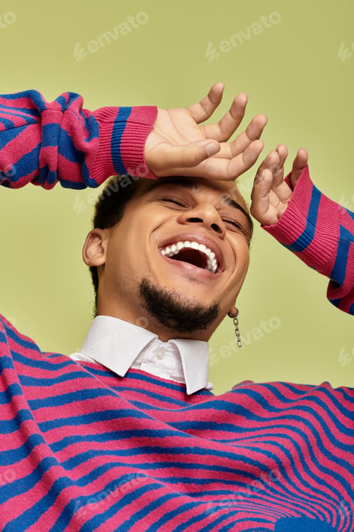 Preview: Stylish young man with a bright smile in an abstract sweatshirt, green backdrop