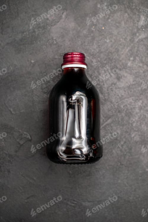 Preview: top view black fruit juice bottle on grey background free space