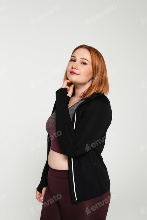 Preview: Body positive sportswoman looking at camera isolated on grey