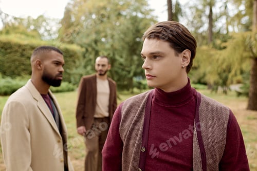 Preview: Handsome men in stylish autumn outfits posing in a serene field surrounded by fall foliage