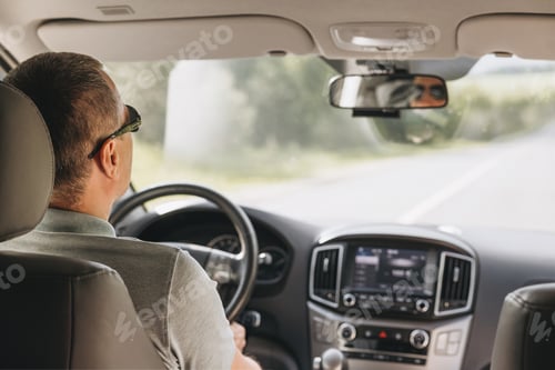 Preview: Young man holding steering wheel while driving car. Road trip adventure