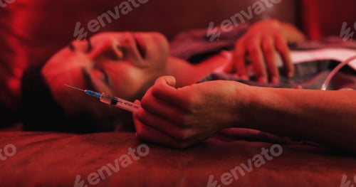 Preview: Drugs, overdose and man on couch with syringe, health risk and narcotic danger in apartment at nigh