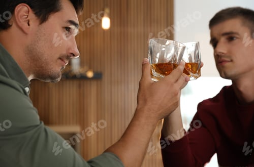 Preview: Young men drinking whiskey together in bar