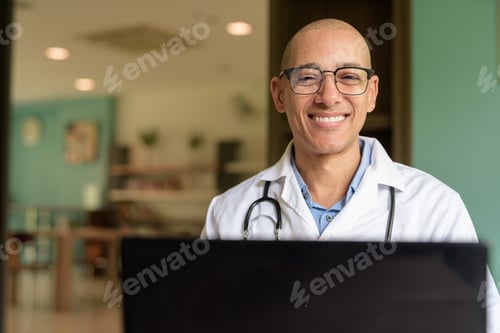 Preview: Doctor Sitting Indoors in Clinic or Hospital Area Library Using Laptop Computer