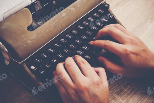 Preview: Hands typing on vintage typewriter on wooden table.