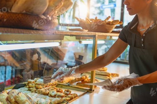 Preview: Female Baker Arranges Delectable Pastries in Bakery Shop