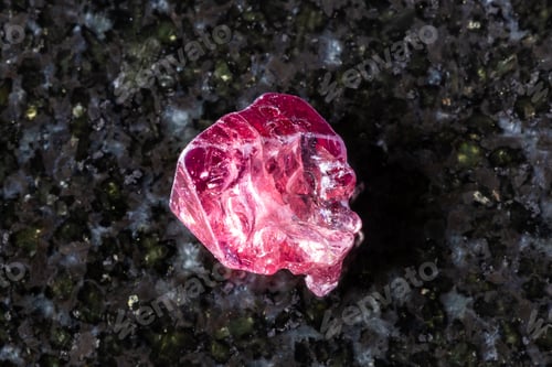 Preview: sample of raw red spinel crystal on black granite