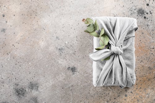 Preview: Eco-friendly fabric reusable gift packaging with eucalyptus. Sustainable gift wrapping. Flat lay