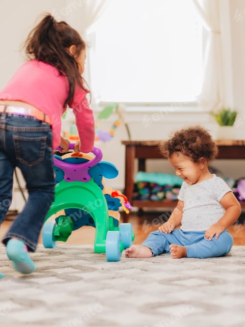Preview: Children Playfully Interacting With a Toy Walker Indoors