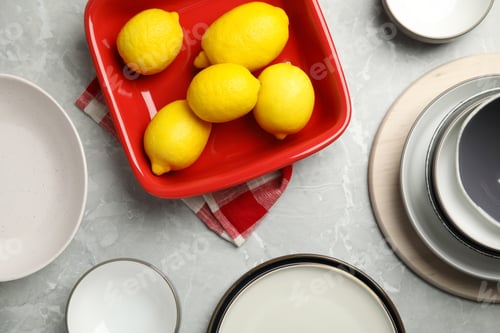 Preview: Set of ceramic dishware and fresh lemons on grey marble table, flat lay