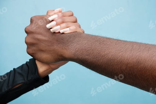 Preview: Man and woman shaking hands. Close up and blue background.