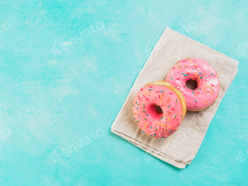 Preview: pink donuts on blue background , copy space, top view