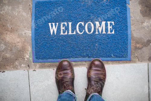 Preview: Welcome mat on ground with person standing next to it