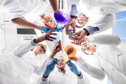 Preview: low angle view of scientists holding various test tubes