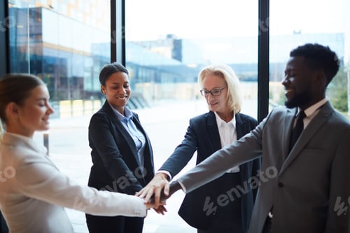 Motivated Business Team Stacking Hands in Corporate Office