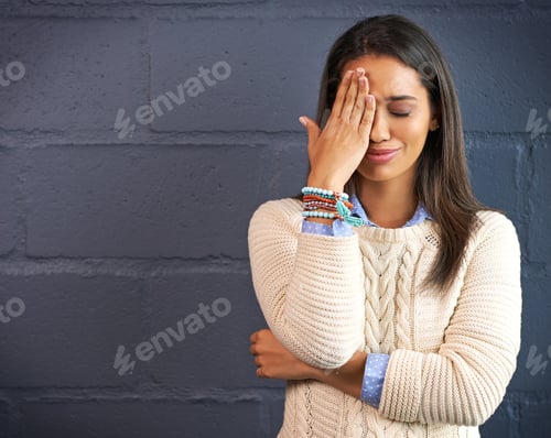 Woman with Hand on Face Standing by Wall