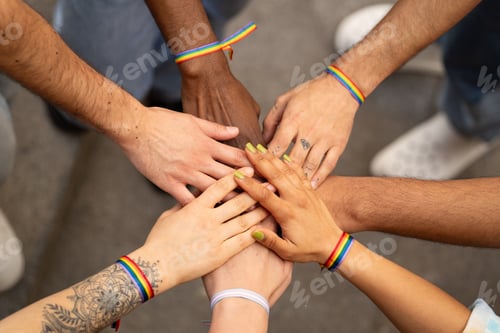 Preview: LGBTQ embrace and greet each other at parade for unity and inclusivity. Hands with rainbow bracelets