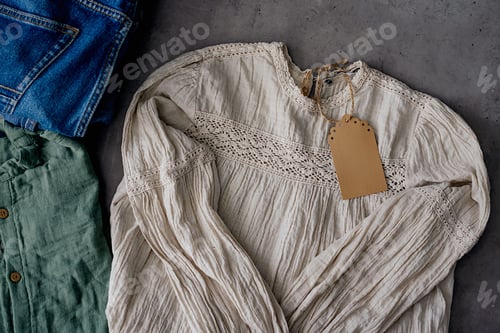 Preview: Clothes from females wardrobe on shelf of second hand store.