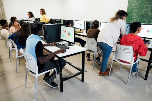 Preview: Young students using computers inside business class at school - Focus on african guy hand