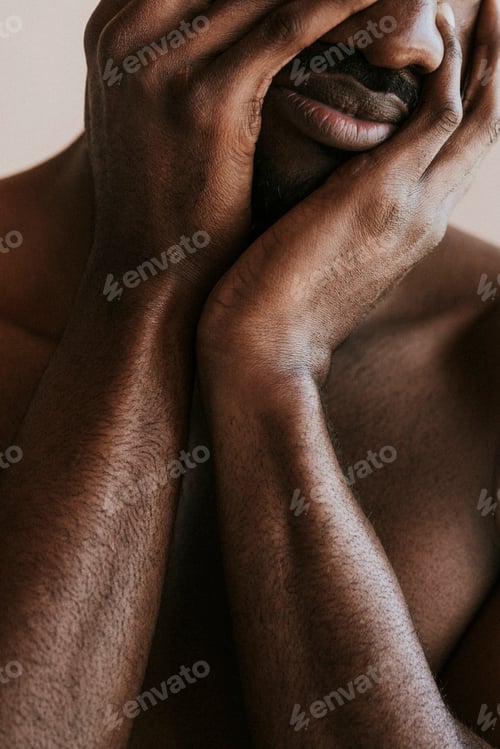Preview: Stressed black man covering his face with hands