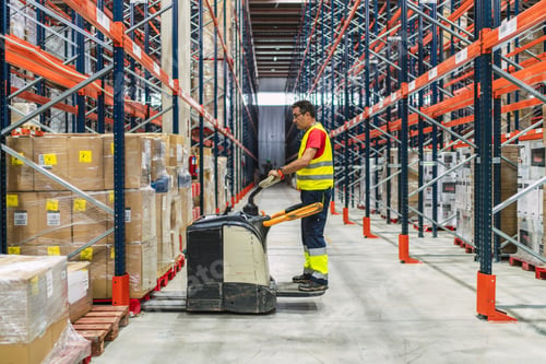 Preview: Warehouse worker driving forklift between shelves full of goods