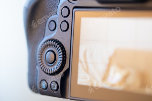 Preview: Close up part of a professional digital camera on a blurred background.