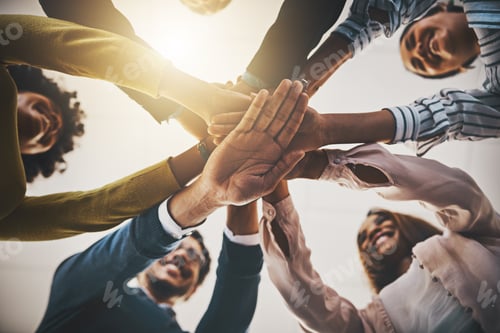 Preview: Low angle shot of a group of businesspeople joining their hands together in a huddle