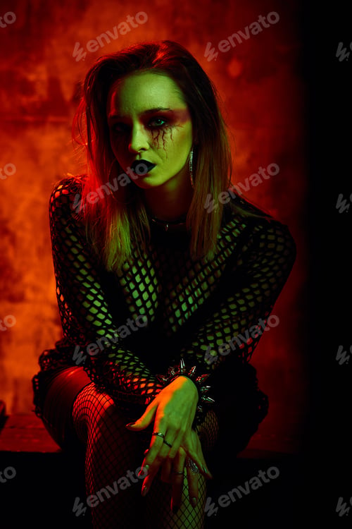 Preview: Female model in halloween outfit posing with on a red background. Gorgeous girl in clothes