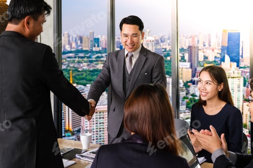 Preview: Successful business team shaking hands, finishing up a meeting.