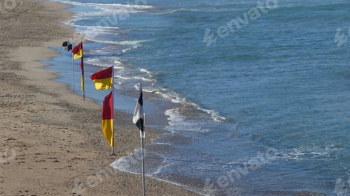 Preview: beach flags along the sand at the beach