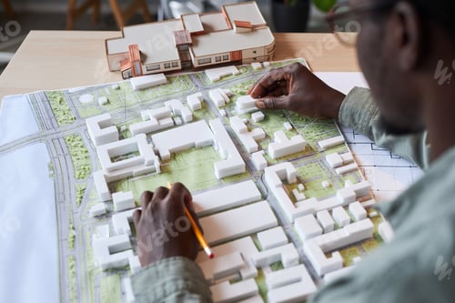 Preview: Architect Examining Building Model and Blueprints