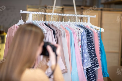 Preview: Woman taking pictures of clothes for online store