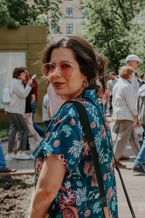 Preview: Woman in Floral Top Surrounded by People