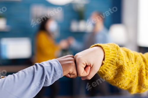 Preview: Close up of african woman and friend doing fist bump greeting each other