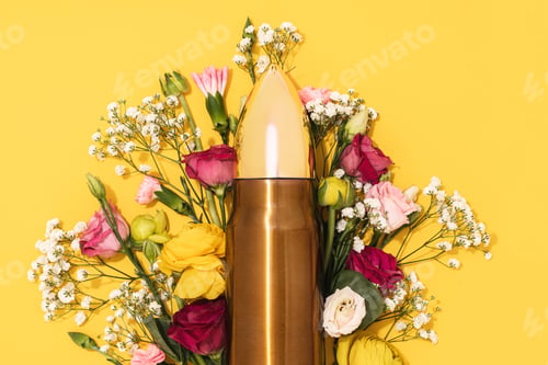 Preview: Pacifism and non-violence movement. Bullet and bunch of different flowers against yellow background.