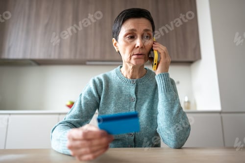 Preview: Nervous woman transferring money to scammers phone fraud deception identity theft financial crime
