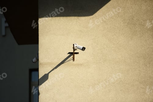 Preview: close up view of security camera on building facade in sunlight