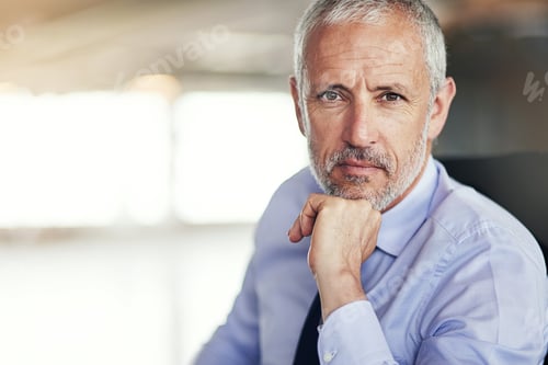 Thoughtful Businessman Poses in Front of Bright Window