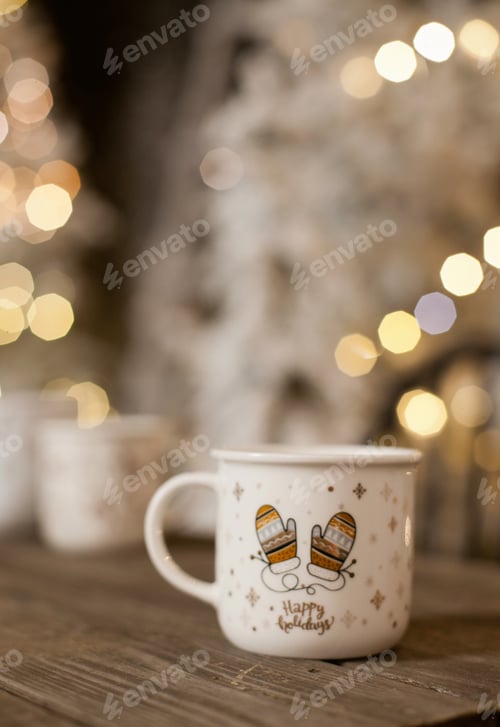 Preview: a cup of coffe with christmas tree lights bokeh as background.Holiday season coffee break.