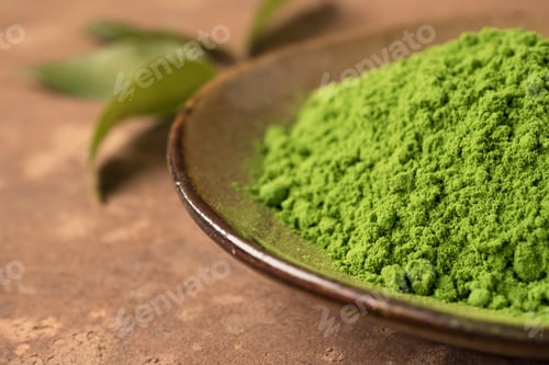 Preview: Close up of green tea powder in ceramic dish with leaf on the table.