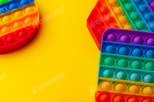Preview: Colorful antistress pop it toy on yellow background