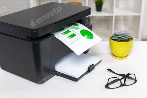 Preview: Printer prints documents with green charts in a modern office setting during the day