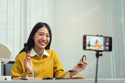 Preview: Beautiful asian woman blogger using camera phone