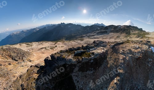 Vista previa: Sunlit Alpine Ridge Over a Vast Mountain Range in British Columbia, Canada, During Clear Sky