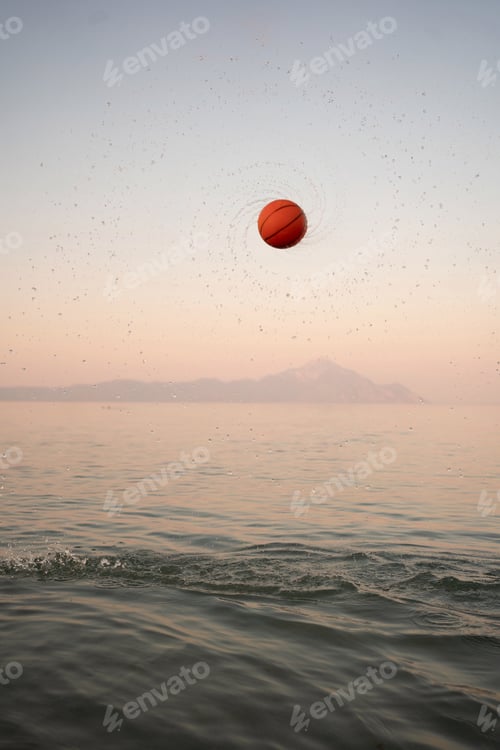 Preview: Family enjoys sunset at the beach playing with a vibrant basketball