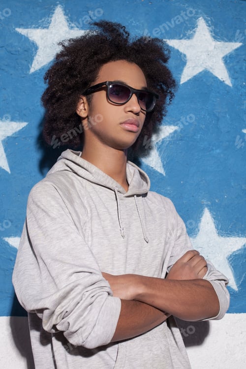 Preview: Cool and confident. Young African man in sunglasses standing and keeping arms crossed