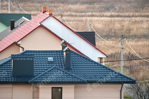 Preview: Residential houses with roof tops covered with metallic and ceramic shingles in rural suburban area