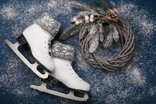 Preview: Pair of ice skates with Christmas decor on blue wooden background, flat lay