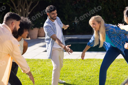 Preview: Playing outdoor game, group of young friends enjoying time together on grass